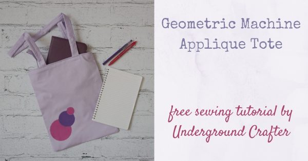 Geometric Machine Applique Tote, free sewing pattern by Underground Crafter - flatlay photo with tote bag with circular appliques, notebook, tablet, and pens on faux brick backdrop