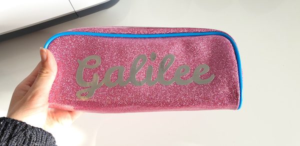Cricut Basics: How To Customize a Pencil Case with Vinyl by How To Heat Press for Underground Crafter | vinyl name in script font on pink glittery pencil case